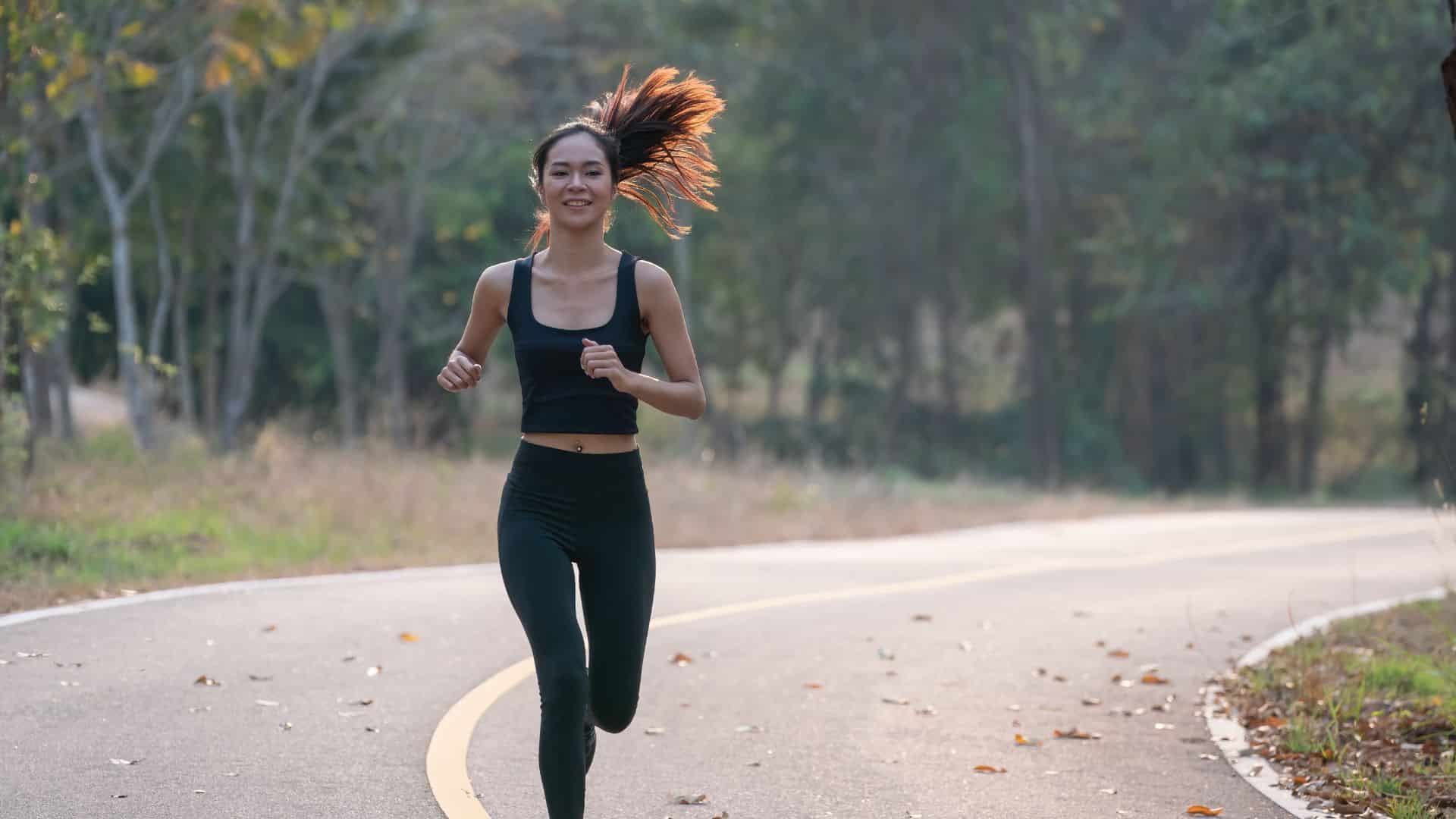 Beginner runner jogging outdoors on a quiet road, showing how to start running for beginners with a simple fitness routine.