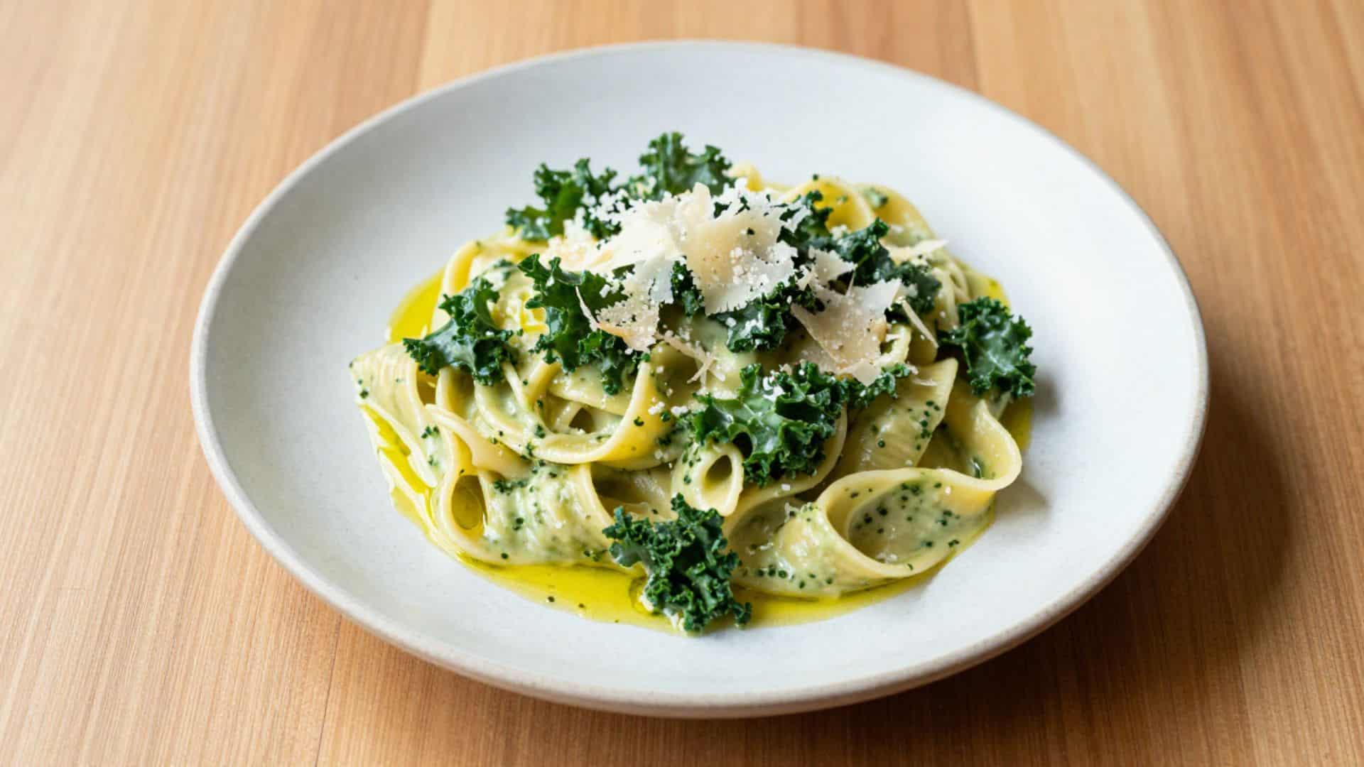 Creamy kale pasta topped with parmesan highlighting kale benefits for heart health, digestion, and nutrient-rich meals.