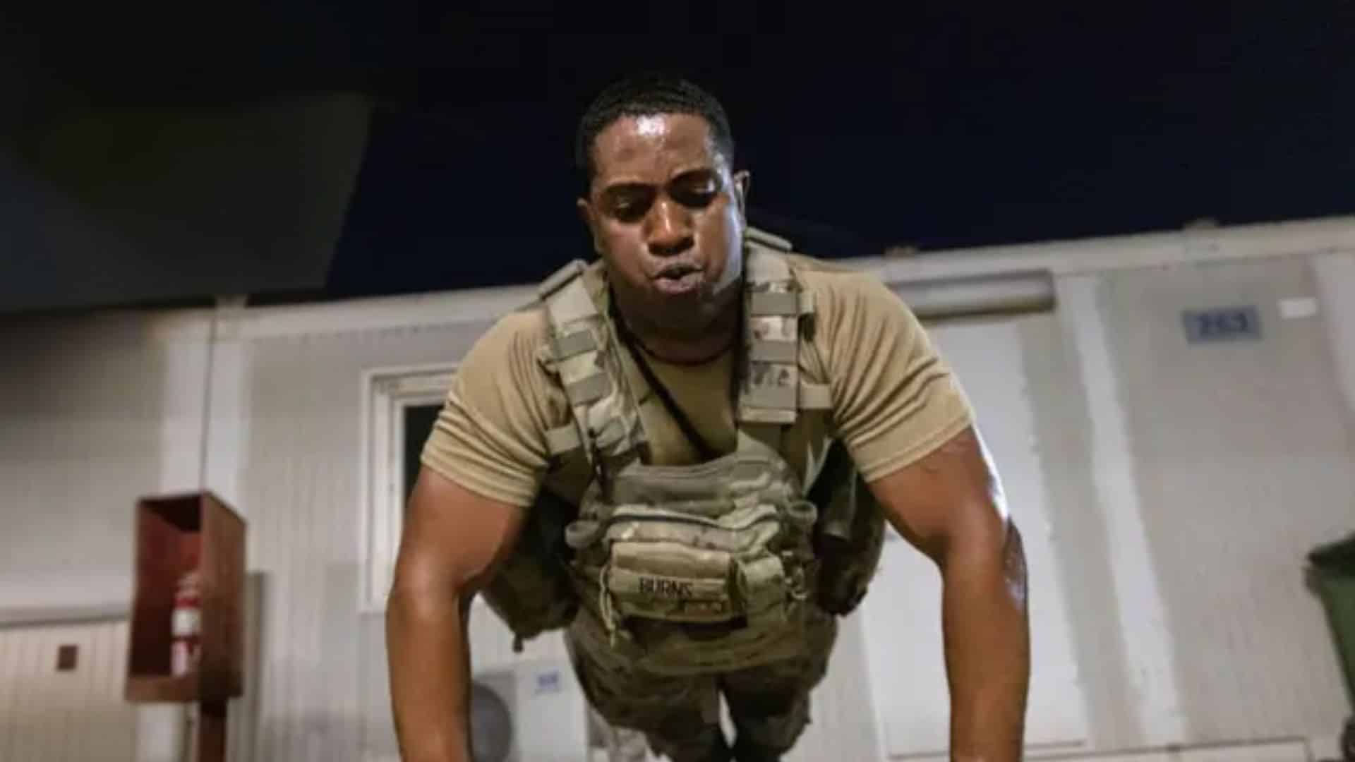 Man doing push-ups in a weighted vest during a Murph workout, showing the intense bodyweight training and endurance challenge.