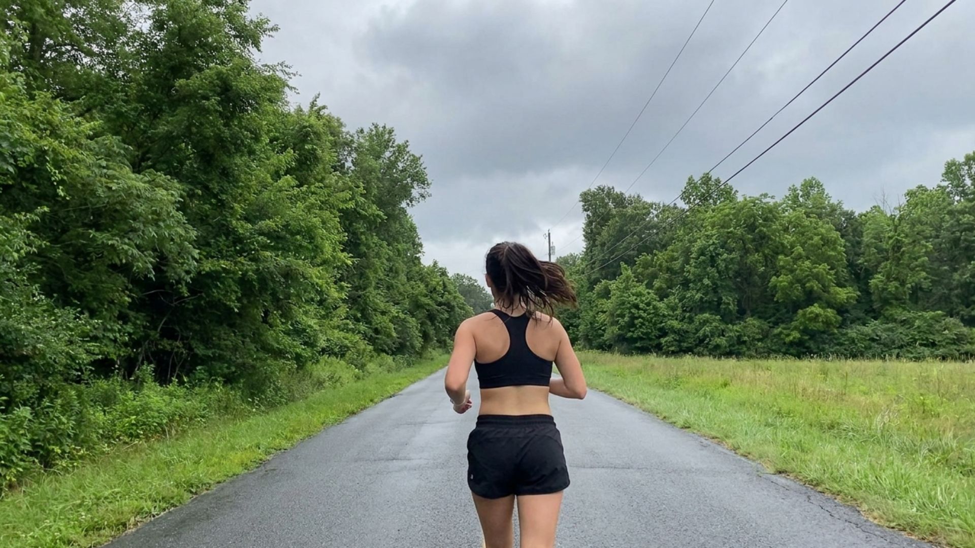 Runner jogging on a quiet road surrounded by trees, highlighting endurance training and what to eat before a long run.