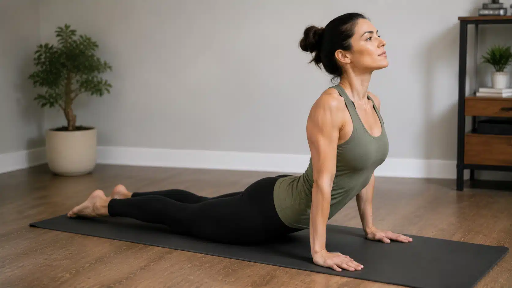 Woman practicing cobra pose chest stretch on a yoga mat to open the chest and improve flexibility.